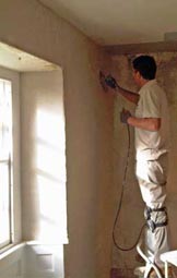 lime finishing coat being applied to a hemp-lime plastered wall