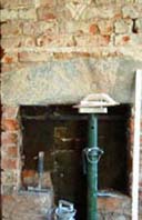 Brick fireplace in need of sensitive repair and lime plaster