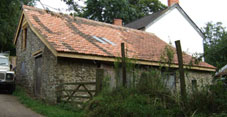 exterior view of repaired barn with cut and pitched roof